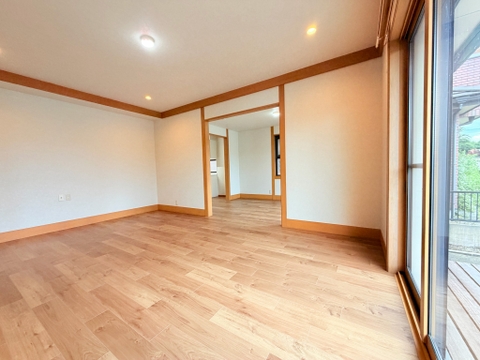 木目調の床と窓がある洋室