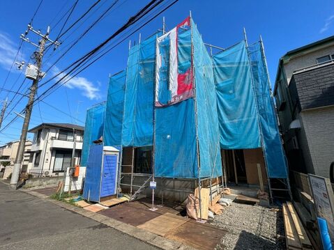 青い養生シートで覆われた建物の外観
