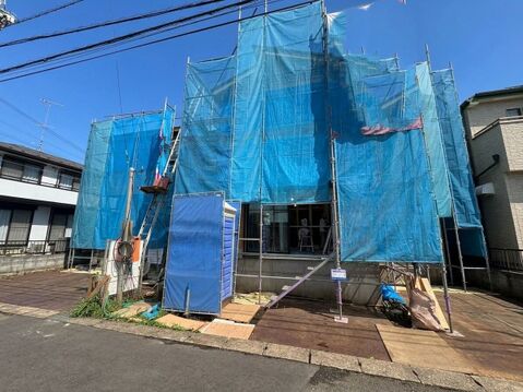 青い養生シートで覆われた建築中の建物