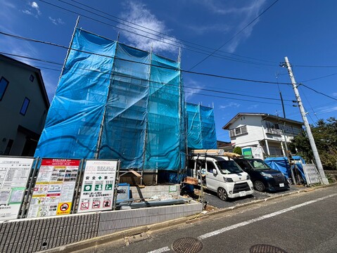 青い外装シートで覆われた建物と前面道路