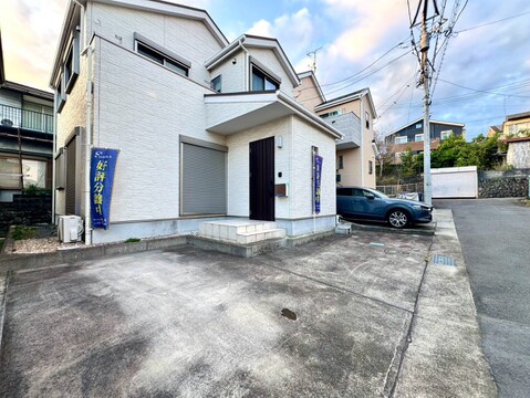 白い戸建て住宅と敷地内の駐車スペース