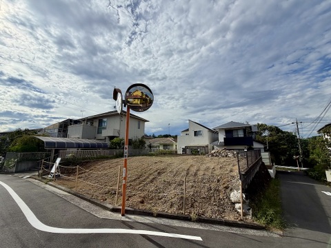 前面道路と傾斜地に建つ住宅の外観