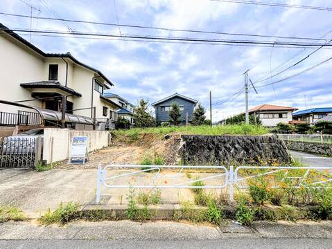 住宅街の建物と前面道路、空き地の様子