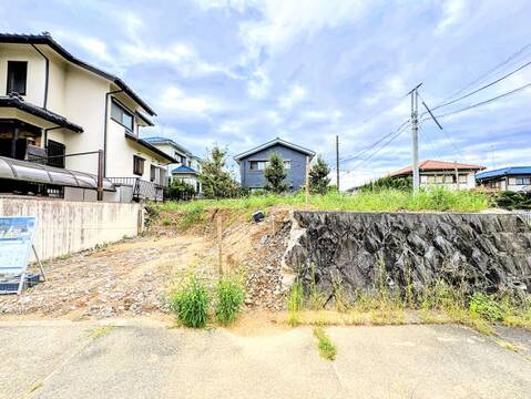 建物前の敷地と石垣を望む外観