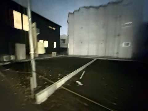 夜間の建物外観と駐車スペース