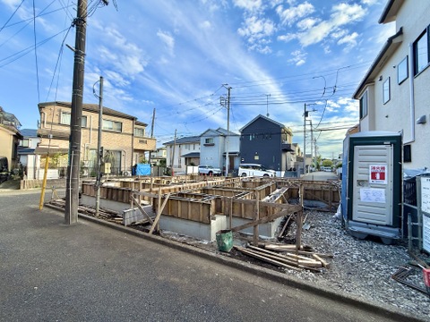 道路沿いの建築中物件と周辺の街並み