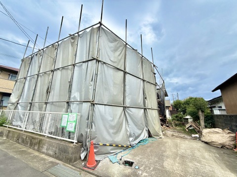 建築中の建物を覆う足場と養生シート
