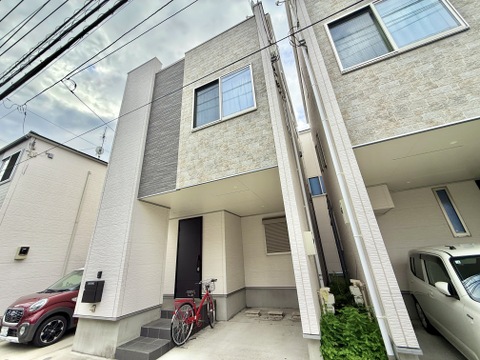 外観と玄関前、駐車スペースを確認できる住宅