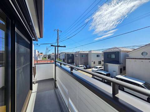 手すり付きのバルコニーから周辺住宅を望む
