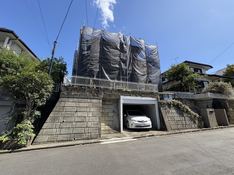 石垣と門扉のある戸建て外観、車庫付き