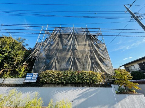 植栽のある住宅外観建物は足場で覆われている