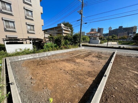 建築中の区画された土地周囲に住宅や建物が見える