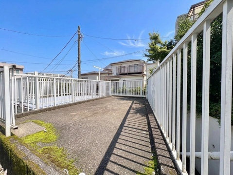 フェンスに囲まれた屋外通路と建物外観