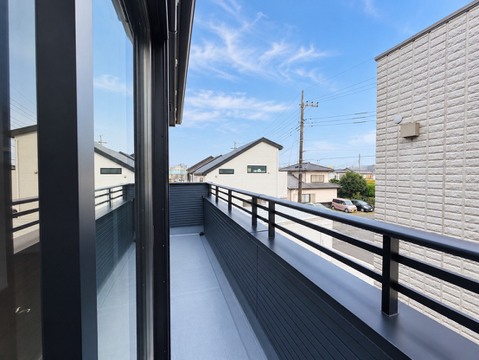 手すり付きの広いバルコニーから周辺住宅を望む