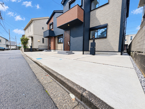 建物外観と前面道路、コンクリート舗装のアプローチ