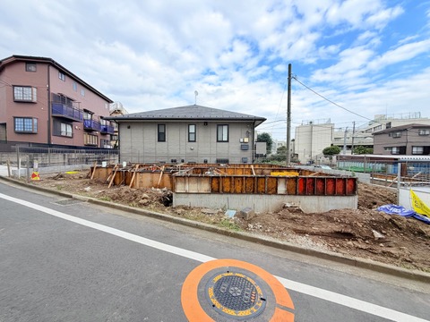 前面道路と建築中の敷地、周辺住宅の様子