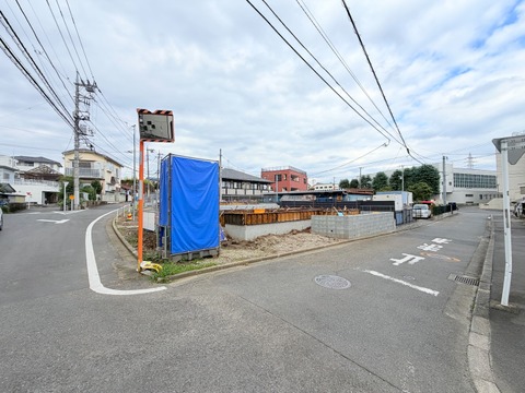 前面道路と周辺の建物を望む物件周辺の様子