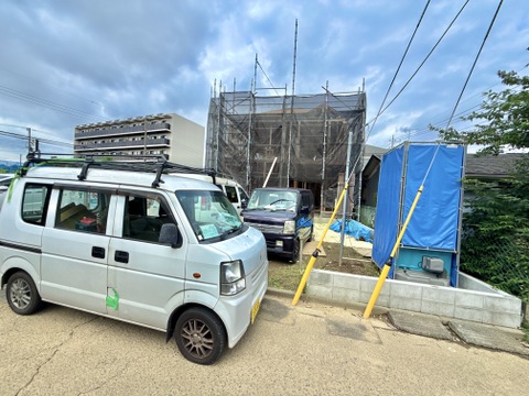 建物前の道路と青いフェンス、駐車車両