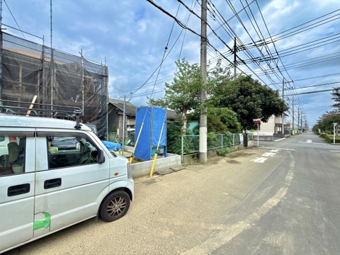 前面道路と周辺の建物・電柱が見える街並み