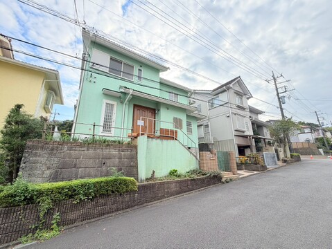 住宅が並ぶ前面道路と緑の植栽