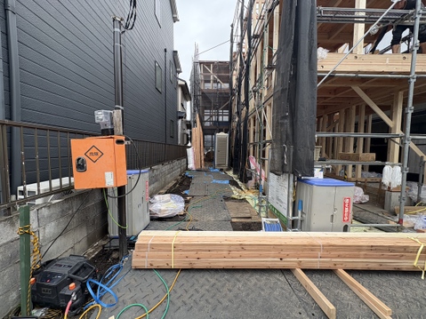 建築中の建物周辺に資材が置かれた通路