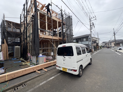 建築中の建物と道路沿いに停車した車