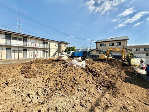 建築中の戸建て住宅と整地中の敷地