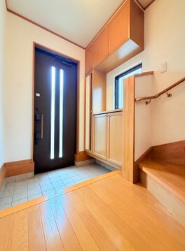 木目調の床と階段がある玄関ホール