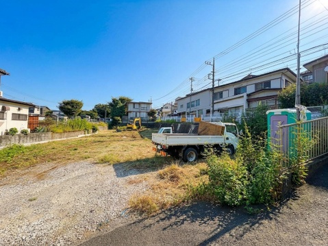 建物と雑草のある未舗装の敷地