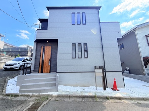 白とグレーの外壁が特徴的な2階建て住宅の外観