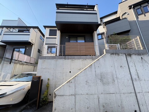 コンクリート擁壁の上に建つ住宅の外観