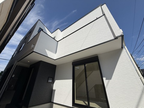 白い外壁と大きな窓が特徴の住宅外観