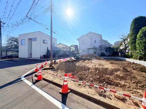 道路沿いの造成中の敷地と周辺住宅