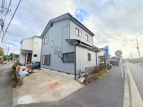 道路沿いに建つ2階建て住宅の外観