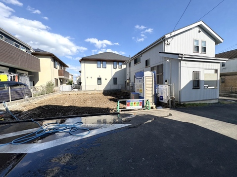 白い外壁の戸建て住宅と前面道路