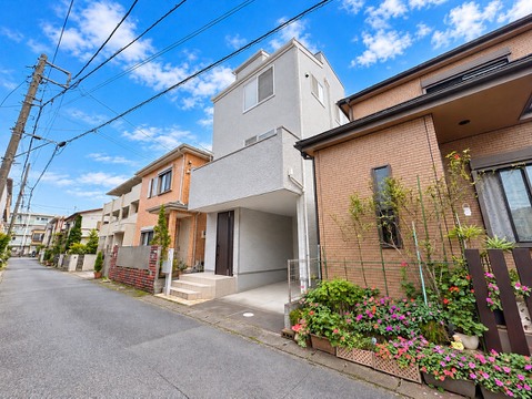 住宅街に建つ戸建ての外観と前面道路