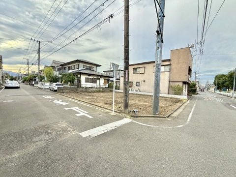 前面道路と角地の建物を望む周辺風景