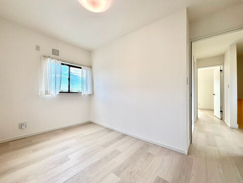 窓のある明るい洋室廊下への出入口が見える