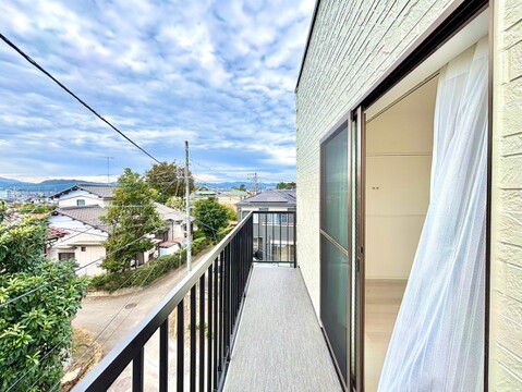 手すり付きのバルコニーから周辺住宅を望む