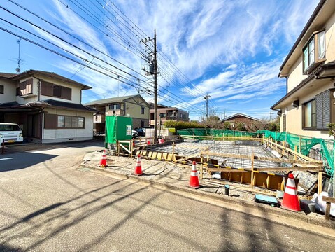 道路沿いの建築現場と周辺の住宅