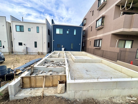 建築中の戸建て住宅と周囲の建物