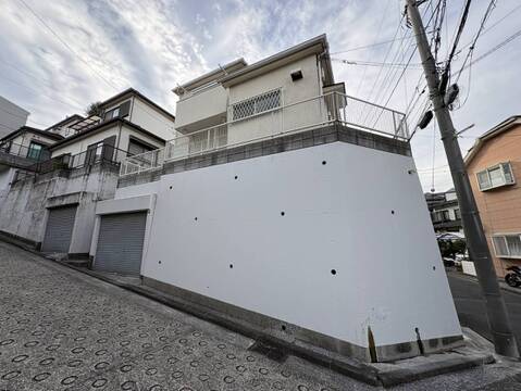 白い外壁の戸建て住宅と前面道路