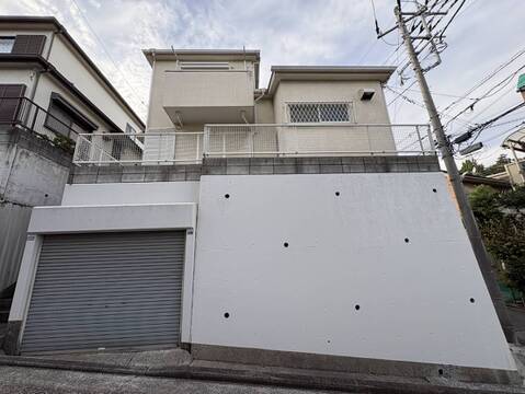 シャッター付き車庫のある白壁の住宅外観