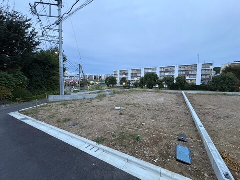 敷地前の道路と周辺の建物を望む外観