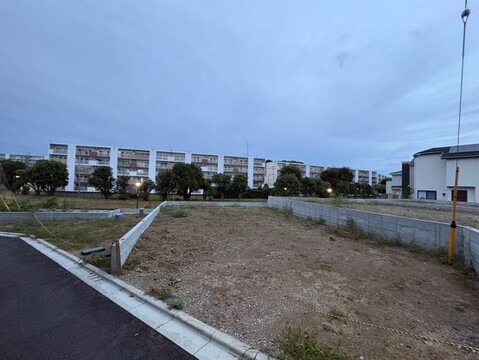 道路沿いの更地と周辺の建物