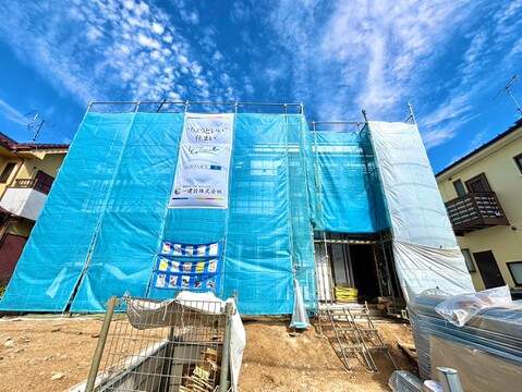 青いシートで覆われた建築中の戸建て外観