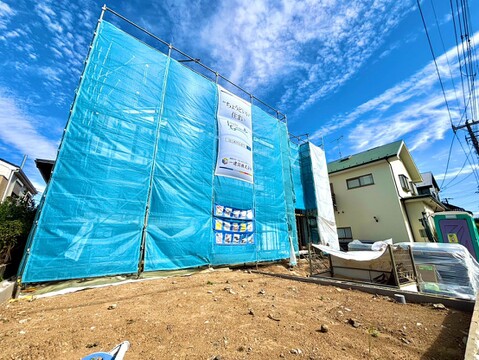 建築中の戸建て外観青い養生シートで覆われています