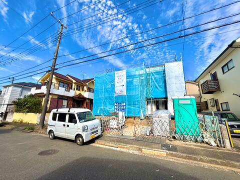 青い外壁の建物と前面道路の様子