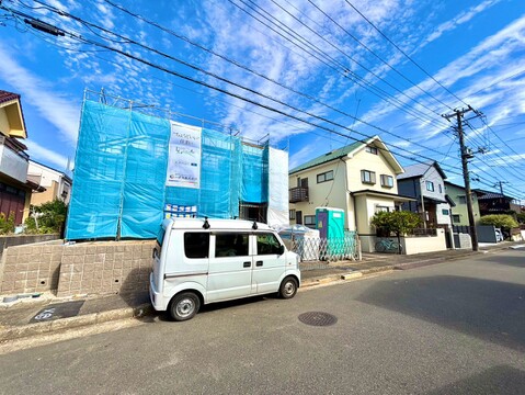 道路沿いに建つ住宅と青空が見える外観
