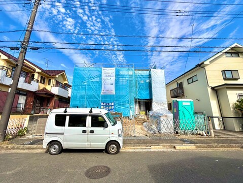 青い外壁の建物と前面道路の様子